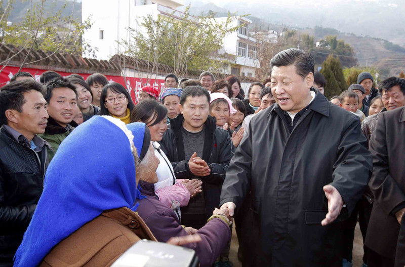 1月19日，習近平離開魯甸縣小寨鎮甘家寨紅旗社區過渡安置點時，同圍攏過來的群眾握手。新華社記者 鞠鵬 攝
