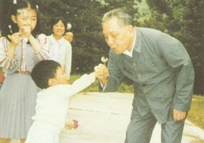 1987年4月，鄧小平在北京玉泉山和孫子一起吹蒲公英