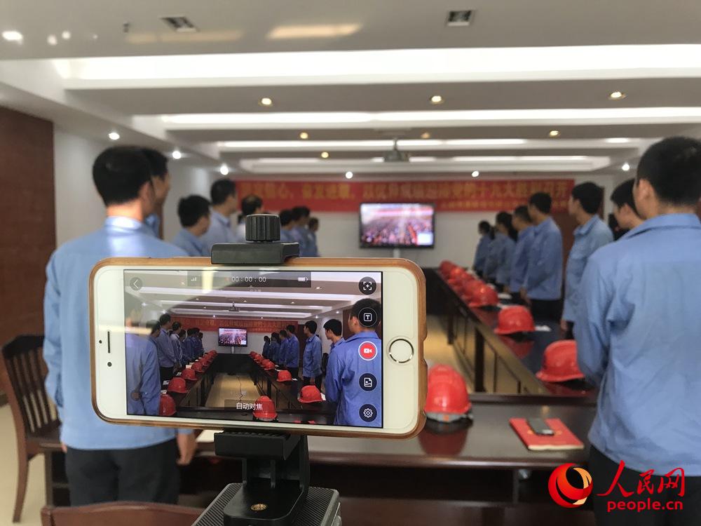 10月18日上午，廣西北海鐵山港作業(yè)區(qū)港口員工觀看黨的十九大開幕會。人民網(wǎng)王芳 攝