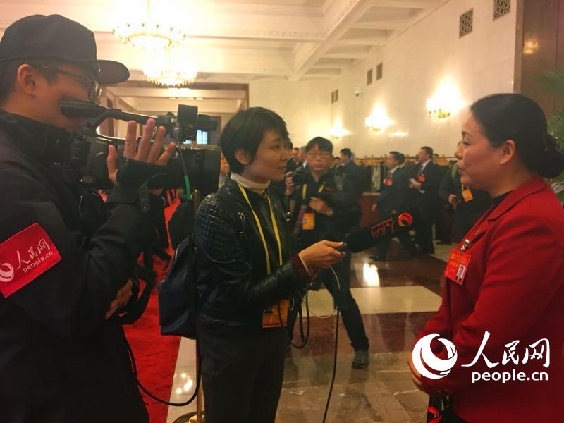 十九大代表走出開幕會現(xiàn)場。圖為代表接受人民網(wǎng)記者採訪，熱議習(xí)近平總書記十九大報告。 （人民網(wǎng)記者 史雅喬 攝）