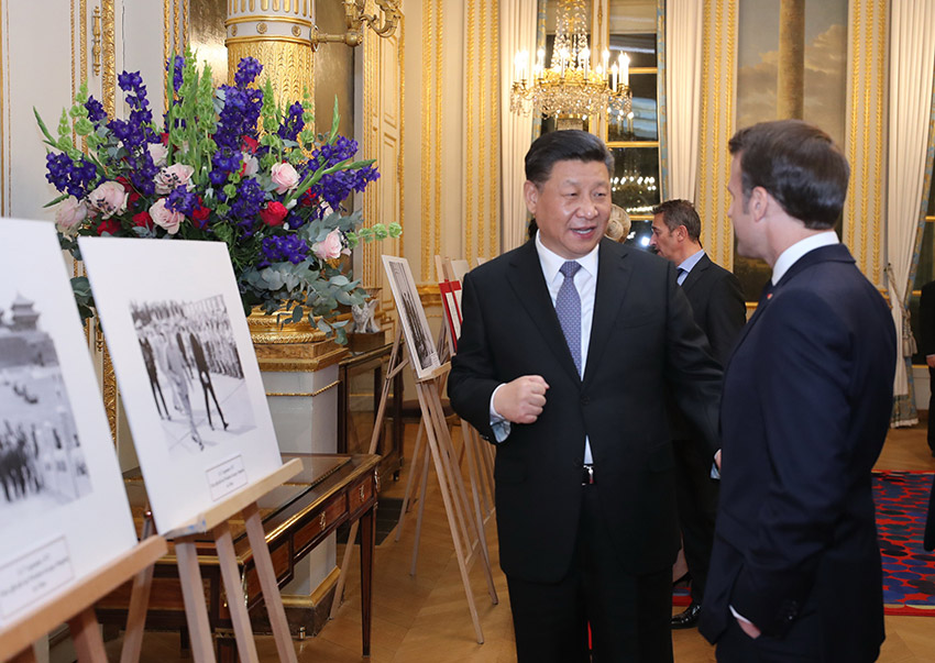 3月25日，國(guó)家主席習(xí)近平在巴黎愛麗舍宮同法國(guó)總統(tǒng)馬克龍參觀中法建交55周年和留法勤工儉學(xué)運(yùn)動(dòng)100周年圖片展。 新華社記者 鞠鵬 攝