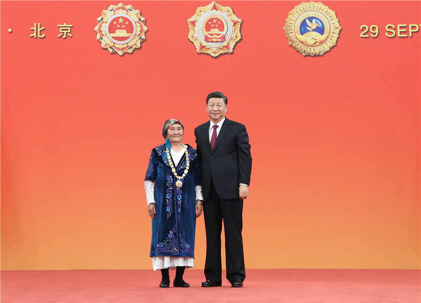 9月29日，中華人民共和國國家勛章和國家榮譽稱號頒授儀式在北京人民大會堂金色大廳隆重舉行。中共中央總書記、國家主席、中央軍委主席習(xí)近平向“人民楷模”國家榮譽稱號獲得者布茹瑪汗·毛勒朵頒授獎?wù)隆?新華社記者 王曄 攝